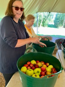 woman smiling whilst she washes apples to press to make apple juice