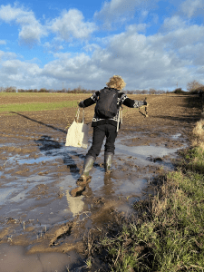 woman walking through muddy puddle in the countryside